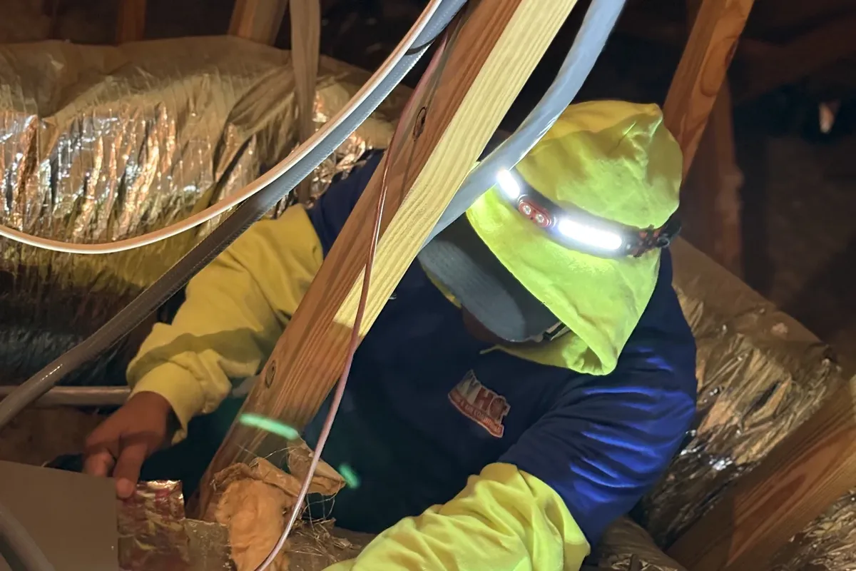 HVAC technician sealing ductwork in an attic to improve air movement and indoor air quality in a Raleigh home