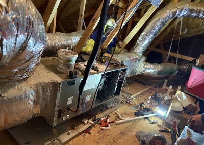 Icy Hot technician installing HVAC system and ductwork in residential attic