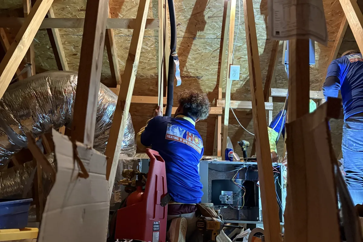 HVAC technician performing professional AC tune-up on an indoor air handler unit
