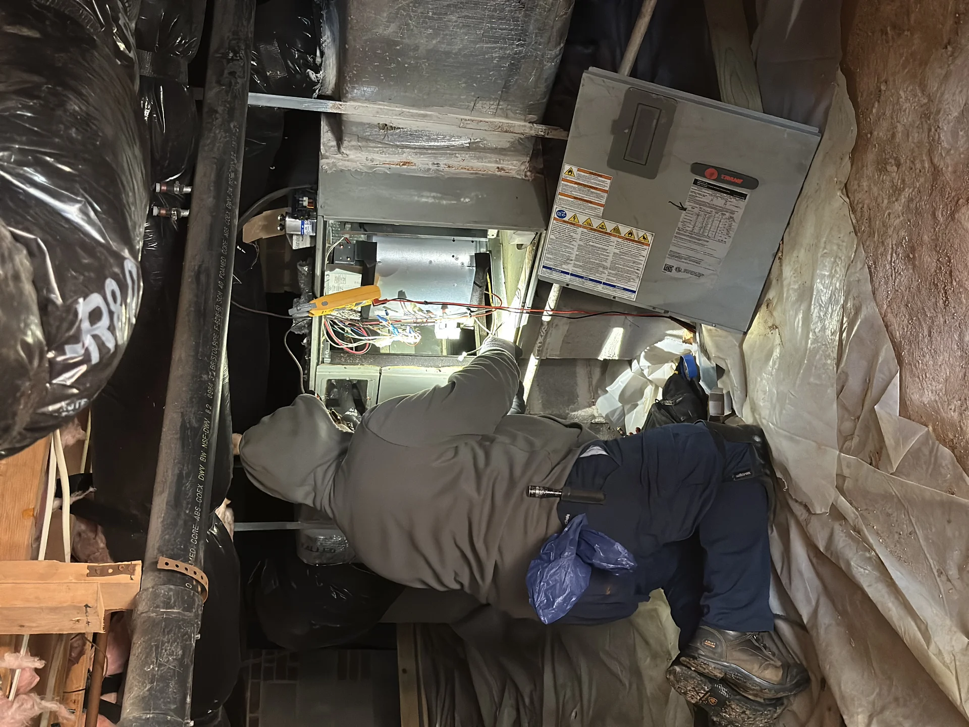 Icy Hot technician diagnosing furnace wiring during a Raleigh service call
