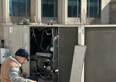 HVAC technician with tool bag servicing commercial rooftop package unit