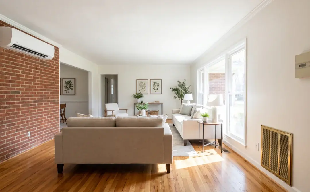 Raleigh living room with both a ductless mini-split head unit and a central air floor vent and thermostat